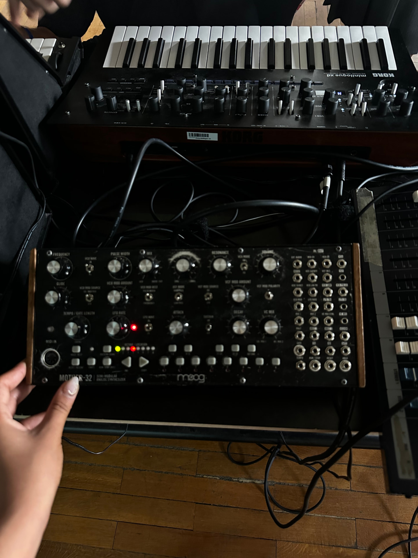 Hands working with synthesisers and electronic music hardware